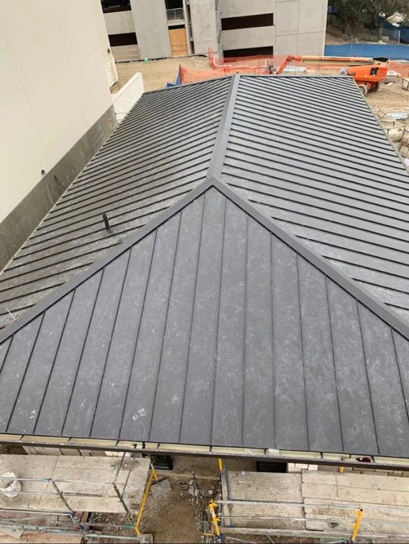 Commercial metal roof construction with crane equipment in Hopkinton